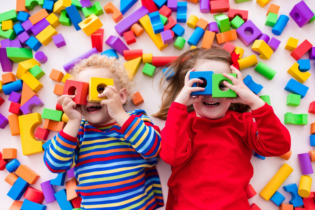 Toddlers with Level 1 Autism playing with colorful blocks.
