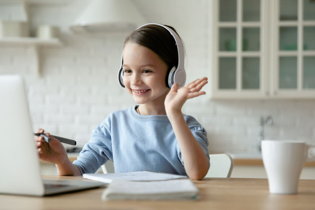 Little girl with a dual diagnosis of ADHD and OCD uses headphones while on laptop. 