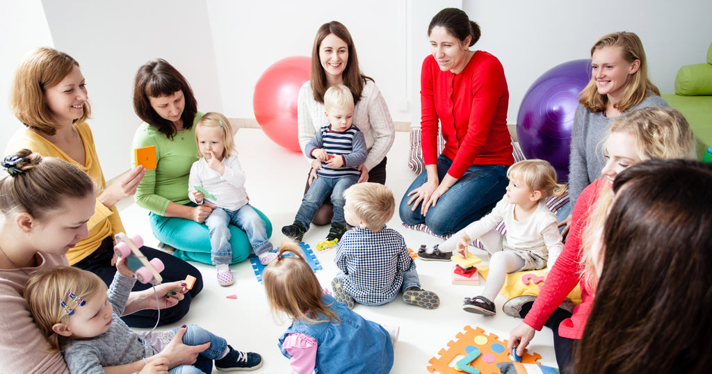 Group of mothers in a circle with their children after they found the best autism support groups in their state.